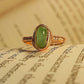 Green aventurine irregular stone ring on vintage book pages showing handmade gold wire wrapped healing crystal jewelry, Sri Lankan spiritual ring featuring natural green gemstone perfect as boho luck stone ring and prosperity amulet for growth and abundance meditation