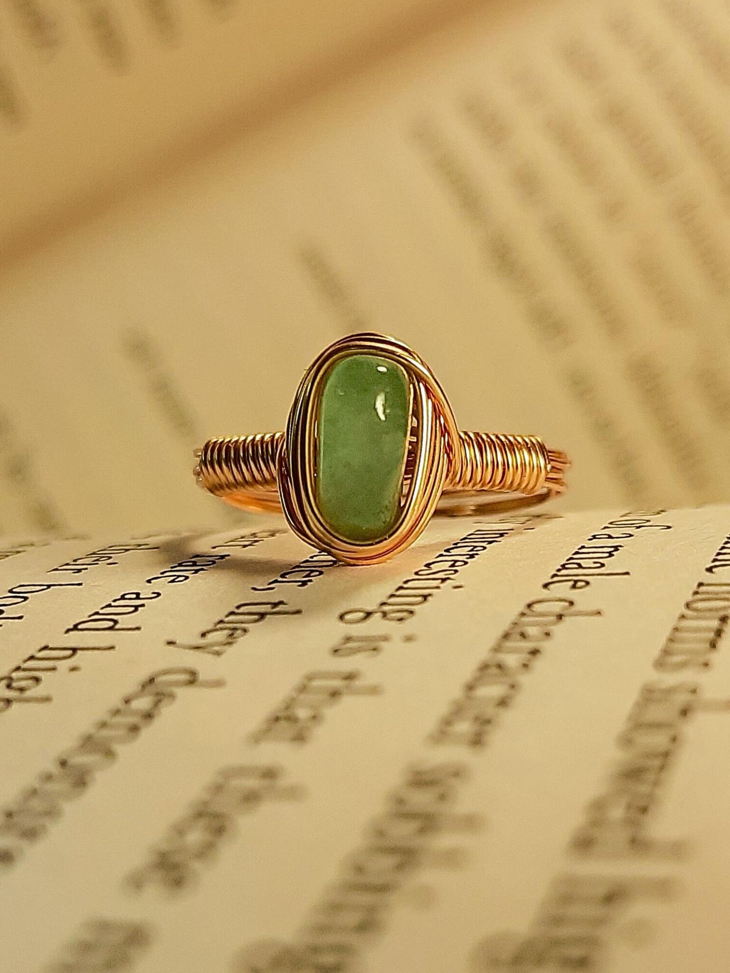 Green aventurine irregular stone ring on vintage book pages showing handmade gold wire wrapped healing crystal jewelry, Sri Lankan spiritual ring featuring natural green gemstone perfect as boho luck stone ring and prosperity amulet for growth and abundance meditation