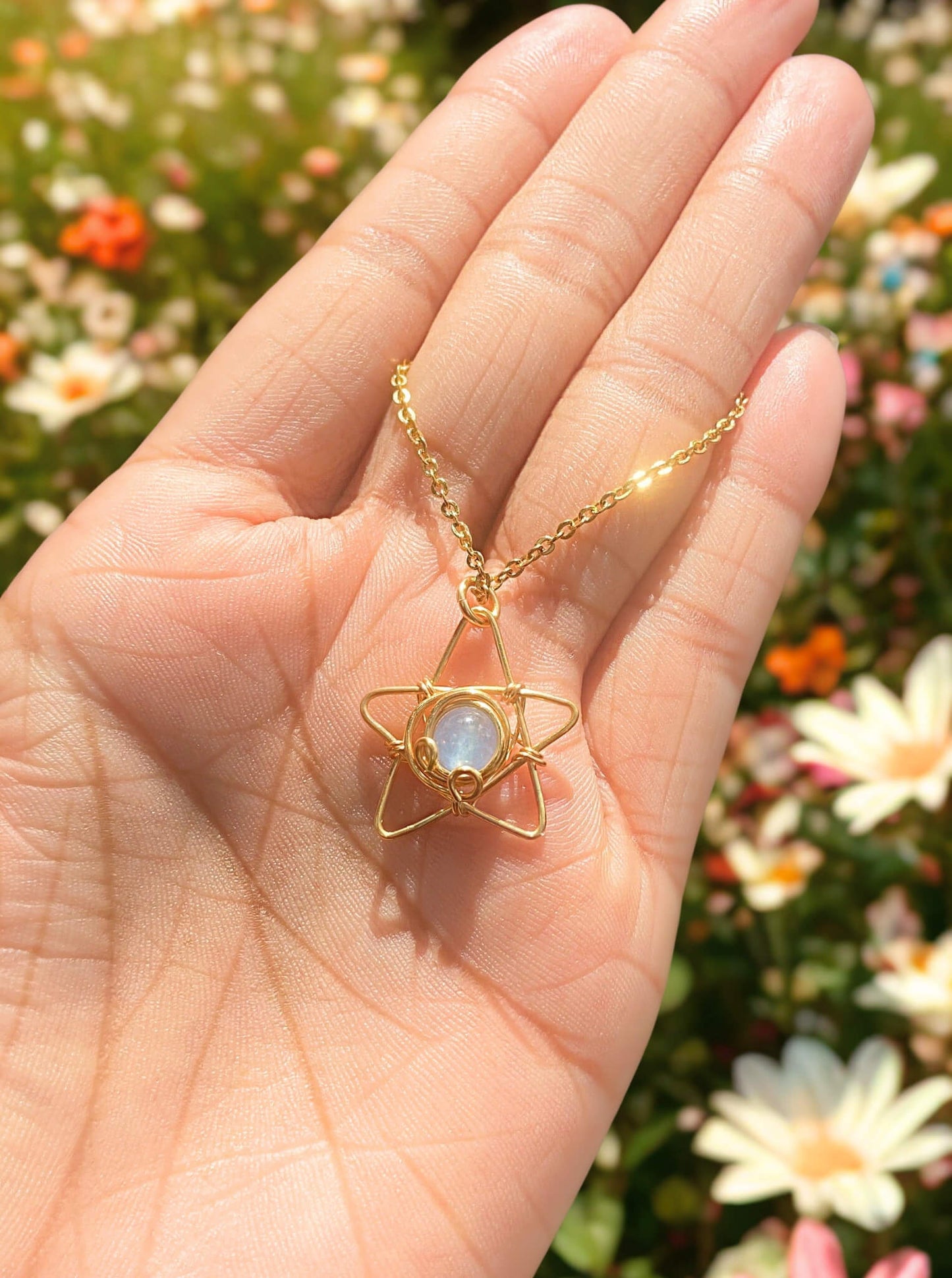 Elegant blue chalcedony star necklace displayed on hand, highlighting the celestial minimalist gold wire wrapped pendant - handmade healing crystal jewelry from Sri Lanka for calming energy and hope