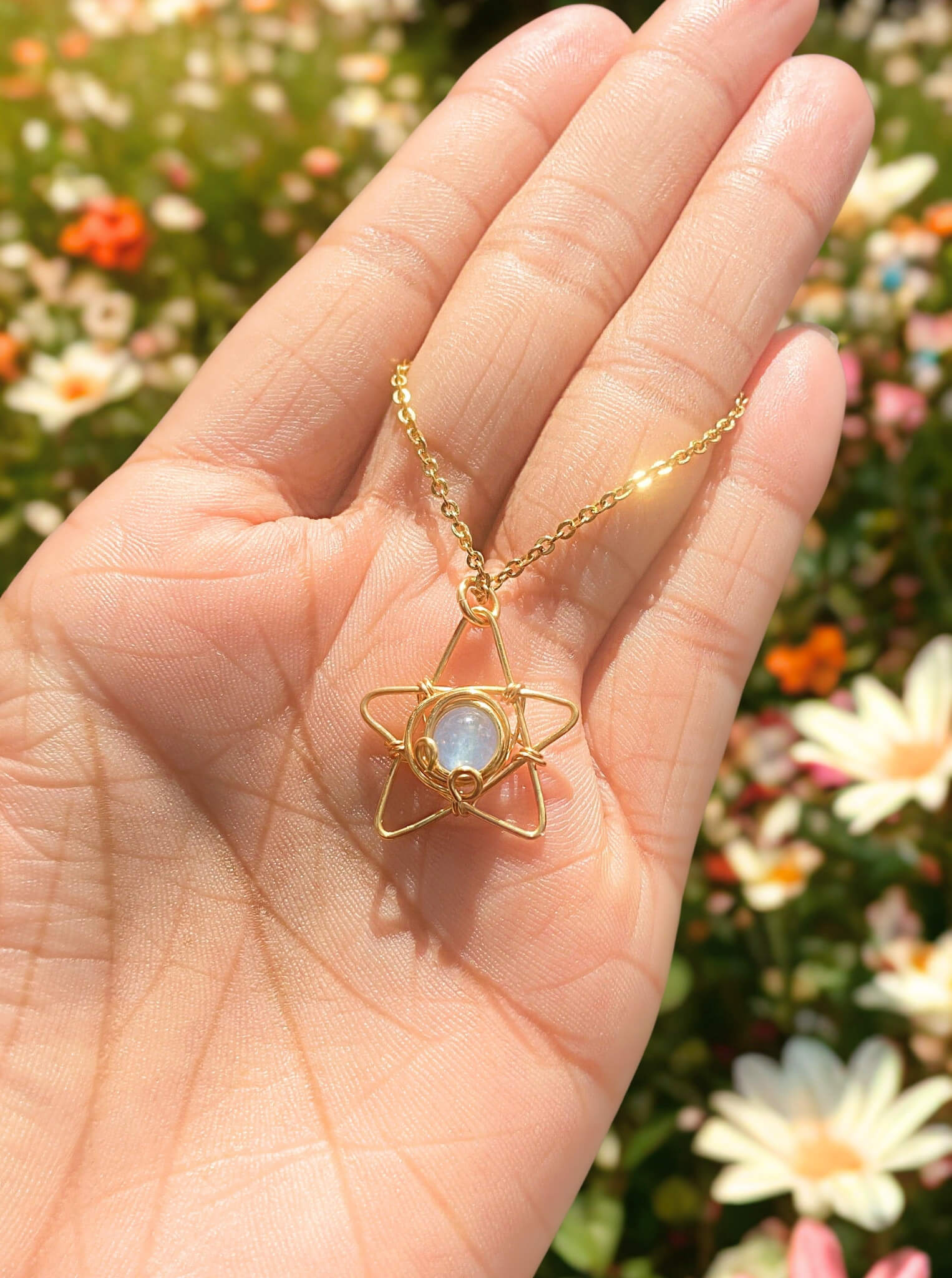 Elegant blue chalcedony star necklace displayed on hand, highlighting the celestial minimalist gold wire wrapped pendant - handmade healing crystal jewelry from Sri Lanka for calming energy and hope