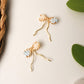 Japanese Miyuki Delica bow earrings handmade with premium glass beads in peach and powder blue, wire-wrapped jewelry by Laganna Sri Lanka, delicate feminine earrings for everyday wear, artisan crafted bow design with graceful wire fall