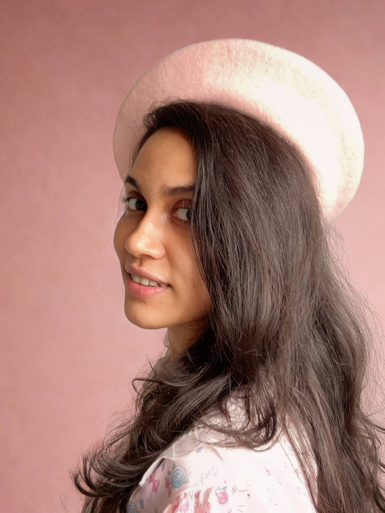 Laganna founder and jewelry artist portrait featuring creative entrepreneur in pink beret against soft pink background - meet the visionary behind handcrafted gemstone jewelry brand from Sri Lanka