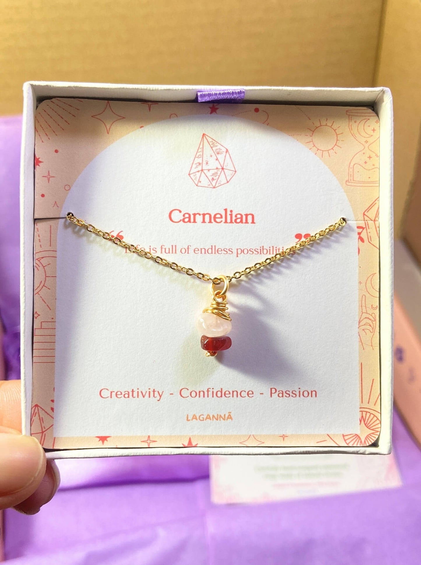 Love Duo irregular stone necklace jewelry box held on hand showing rose quartz and carnelian, handmade Sri Lankan gold wire wrapped dual crystal pendant gift for emotional healing