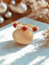  Love Duo braided ring with rose quartz and carnelian on tabletop, handmade Sri Lankan gold wire wrapped dual crystal ring for heart chakra and creativity
