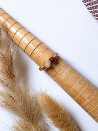 Love Duo Ring rose quartz and carnelian gold wire wrapped resting on bamboo prop with pampas grass flat lay, handmade healing crystal ring Sri Lanka – love creativity emotional balance Laganna
