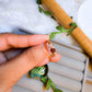 Love Duo ring with rose quartz and carnelian held on hand, handmade Sri Lankan gold wire wrapped dual crystal ring for self-love and creative energy