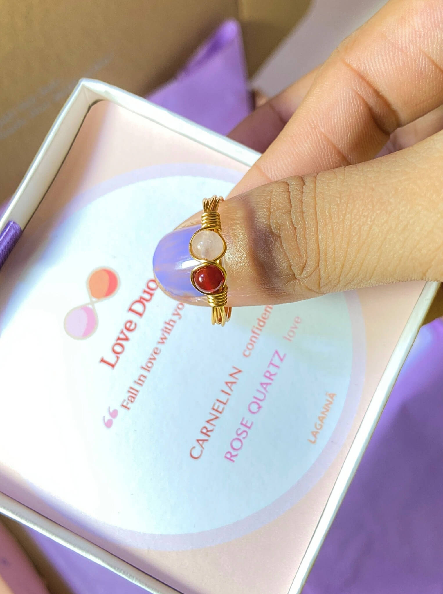  Love Duo ring with rose quartz and carnelian held on hand, handmade Sri Lankan gold wire wrapped dual crystal ring for self-love and creative energy