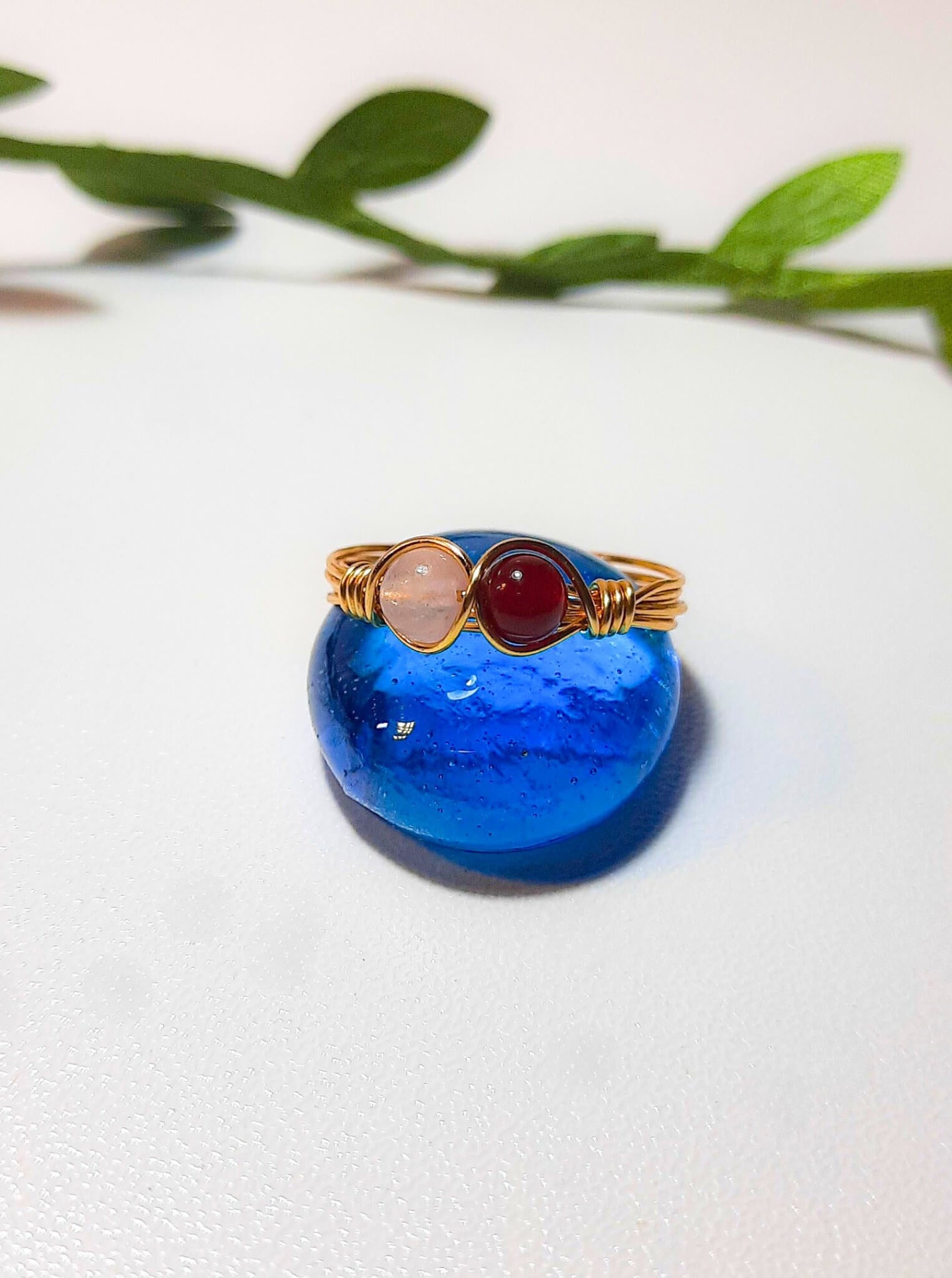 Love Duo ring with rose quartz and carnelian jewelry box on white background, handmade Sri Lankan gold wire wrapped dual crystal ring gift for love and creativity