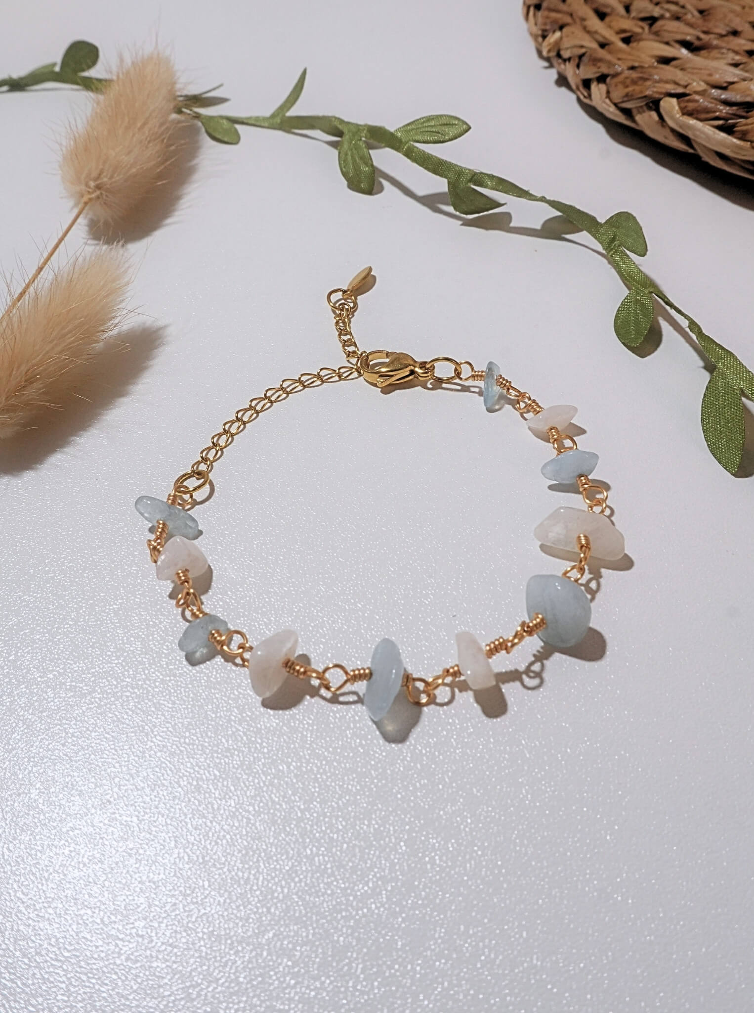 Moon and Sea Bracelet moonstone and aquamarine chip stones gold wire wrapped overhead flat lay with pampas grass and eucalyptus leaves, handmade healing crystal bracelet Sri Lanka – emotional healing inner calm new beginnings Laganna
