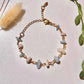 Moon and Sea bracelet flat lay top view showing moonstone and aquamarine chip stones, handmade Sri Lankan gold wire wrapped dual crystal bracelet for emotional healing and inner calm