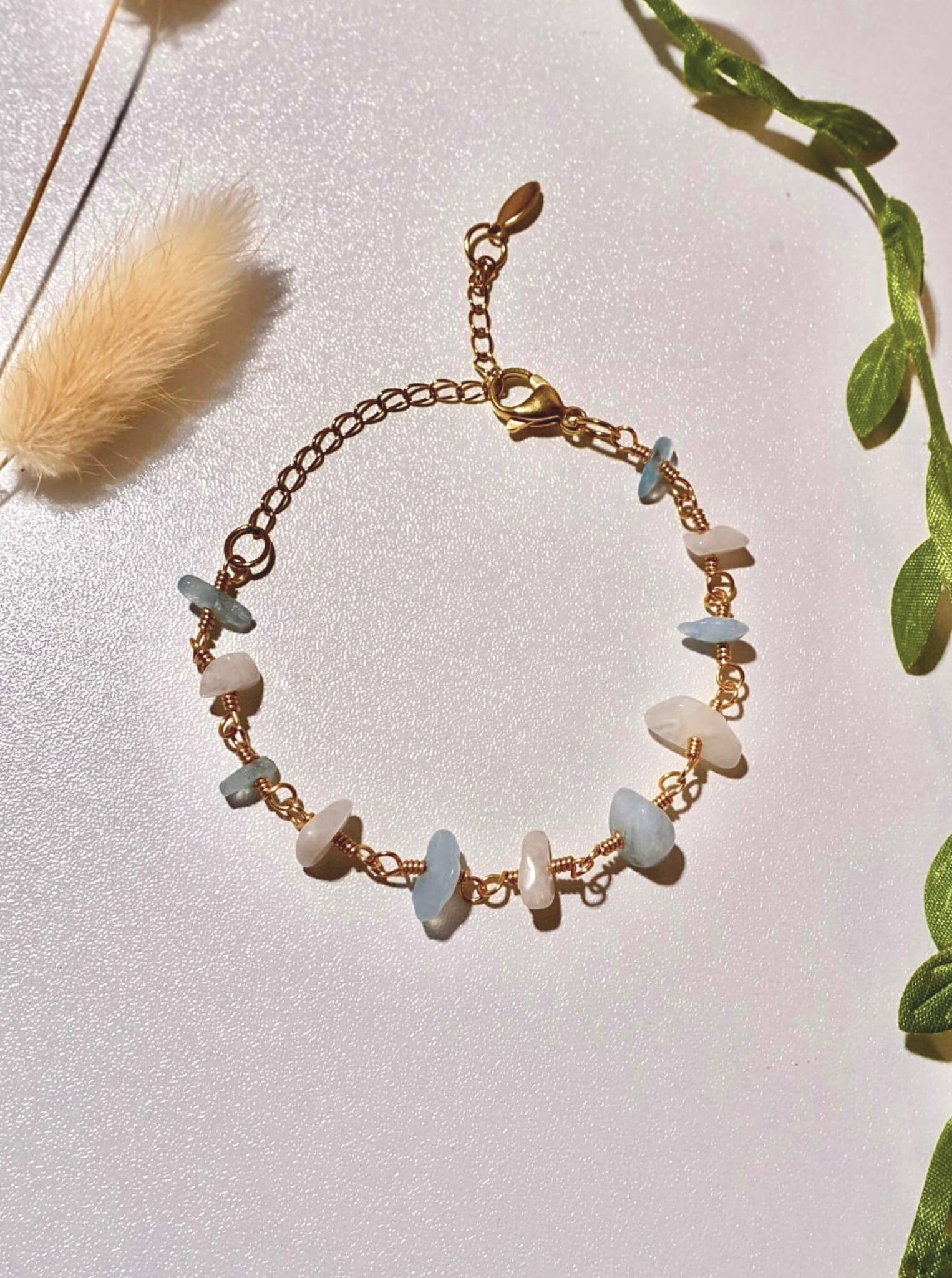 Moon and Sea bracelet flat lay top view showing moonstone and aquamarine chip stones, handmade Sri Lankan gold wire wrapped dual crystal bracelet for emotional healing and inner calm