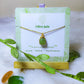 Handmade olive jade square stone necklace in gold wire wrapped design on jewelry card featuring natural healing crystal jewelry crafted by Sri Lankan artisans as heart chakra balancing pendant and abundance enhancement amulet for women seeking prosperity and emotional healing with geometric green gemstone