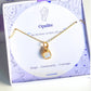 Opalite square stone necklace jewelry box closeup showing gold wire wrapped design, handmade Sri Lankan healing crystal pendant for crown chakra and spiritual clarity