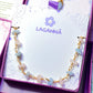 Laganna handmade Petal and Sea gold wire wrapped bracelet with rose quartz and aquamarine for love and calm in jewelry box