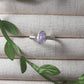 Natural purple jade irregular stone ring on jewelry display showing handmade silver wire wrapped healing crystal jewelry, Sri Lankan artisan wisdom stone ring featuring raw purple gemstone perfect as boho spiritual ring and crown chakra amulet for inner peace and tranquility