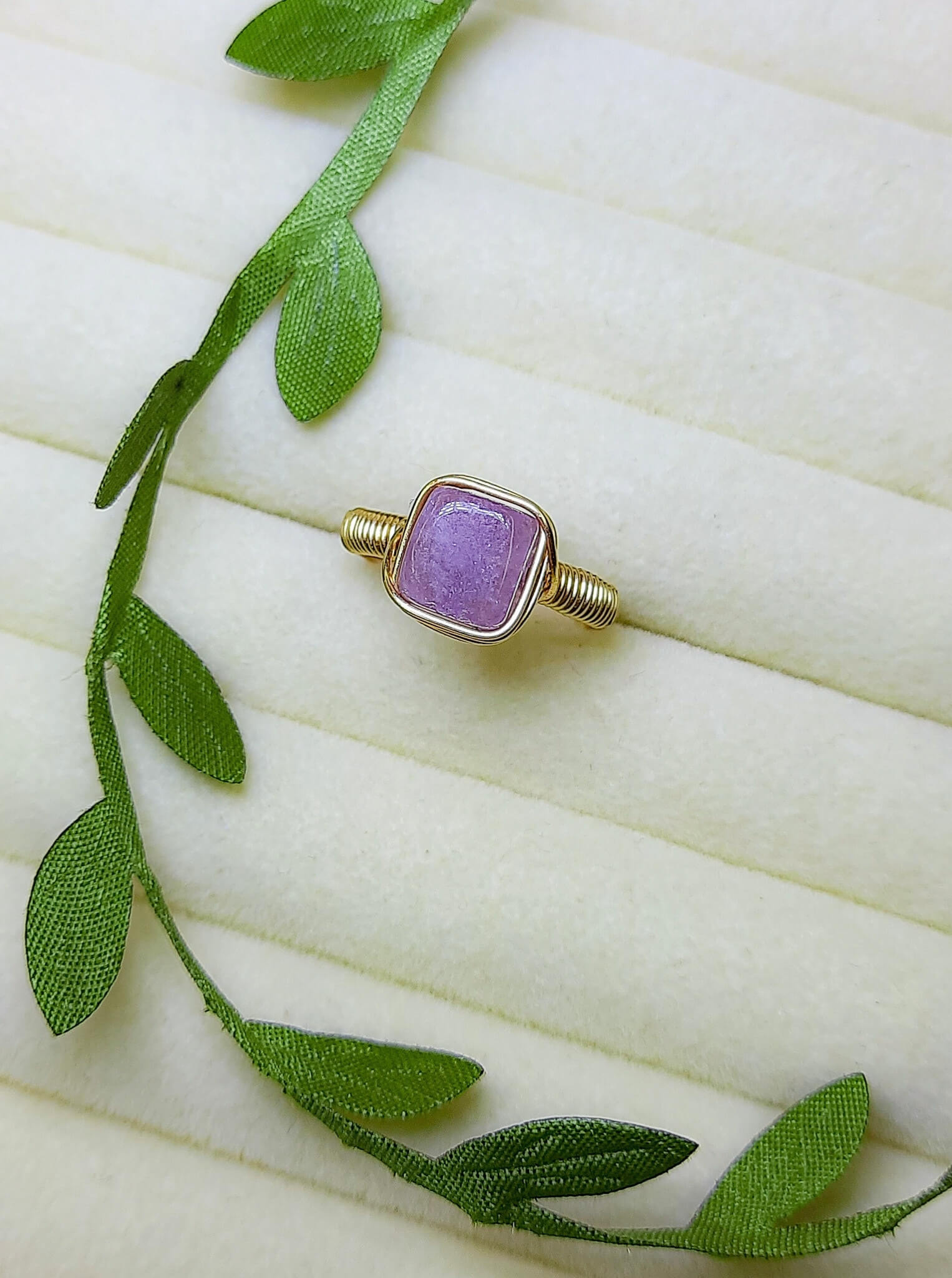 Handmade purple jade square stone ring in gold wire wrapped design on aesthetic jewelry display featuring natural healing crystal jewelry crafted by Sri Lankan artisans as crown chakra balancing ring and wisdom enhancement amulet for women seeking spiritual growth and inner peace with geometric purple gemstone