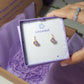 Purple Jade Petite Round Stud Earrings packaging with crystal meaning card - handcrafted wire-wrapped healing jewelry gift from Sri Lanka featuring natural purple jade stone for positivity, creativity, and wisdom