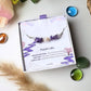 Purple Lake Bracelet silver wire wrapped amethyst freshwater pearl purple jade in Laganna jewelry box overhead flat lay with pampas grass and glass stones, handmade healing crystal bracelet Sri Lanka – spiritual protection gentle wisdom
