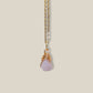 Rose quartz irregular stone necklace on light background showing gold wire wrapped design, handmade Sri Lankan healing crystal pendant for emotional healing