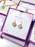 Rose Quartz Statement Round Stud Earrings packaging with crystal meaning card - handcrafted wire-wrapped healing jewelry gift from Sri Lanka featuring natural rose quartz stone for love, tenderness, and compassion
