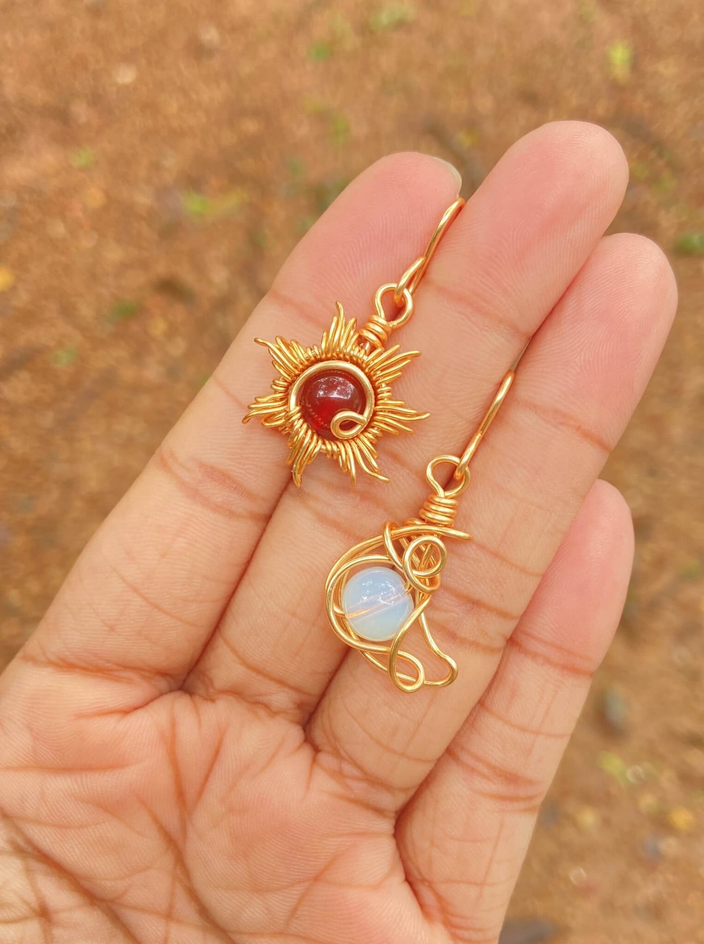 Beautiful Sun & Moon Dangle Earrings featuring Carnelian and Opalite healing crystals, handmade gold wire wrapped celestial jewelry from Sri Lanka by Laganna, shown on hand stylish bohemian accessories
