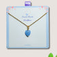 Handmade sweet heart blue chalcedony necklace in gold wire wrapped design on display card featuring natural healing crystal jewelry crafted by Sri Lankan artisans as throat chakra balancing pendant and communication enhancement amulet for women seeking calm and emotional healing with heart-shaped blue gemstone