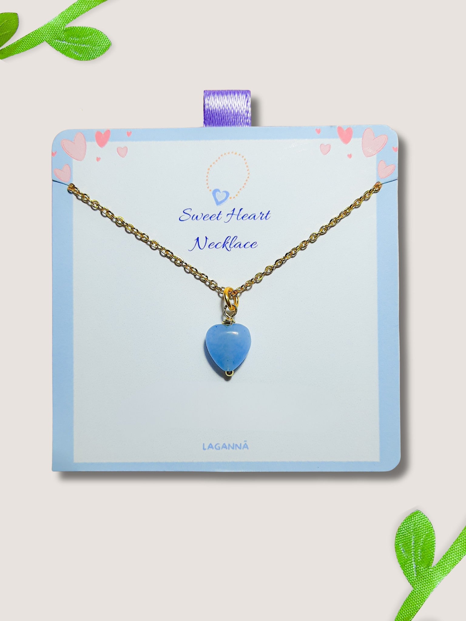 Handmade sweet heart blue chalcedony necklace in gold wire wrapped design on display card featuring natural healing crystal jewelry crafted by Sri Lankan artisans as throat chakra balancing pendant and communication enhancement amulet for women seeking calm and emotional healing with heart-shaped blue gemstone