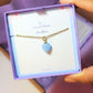 Sweet heart blue chalcedony necklace jewelry box held in hand showing handmade gold wire wrapped healing crystal gift set, Sri Lankan artisan throat chakra pendant featuring natural heart-shaped blue gemstone perfect as communication jewelry gift for calm and emotional healing with elegant presentation