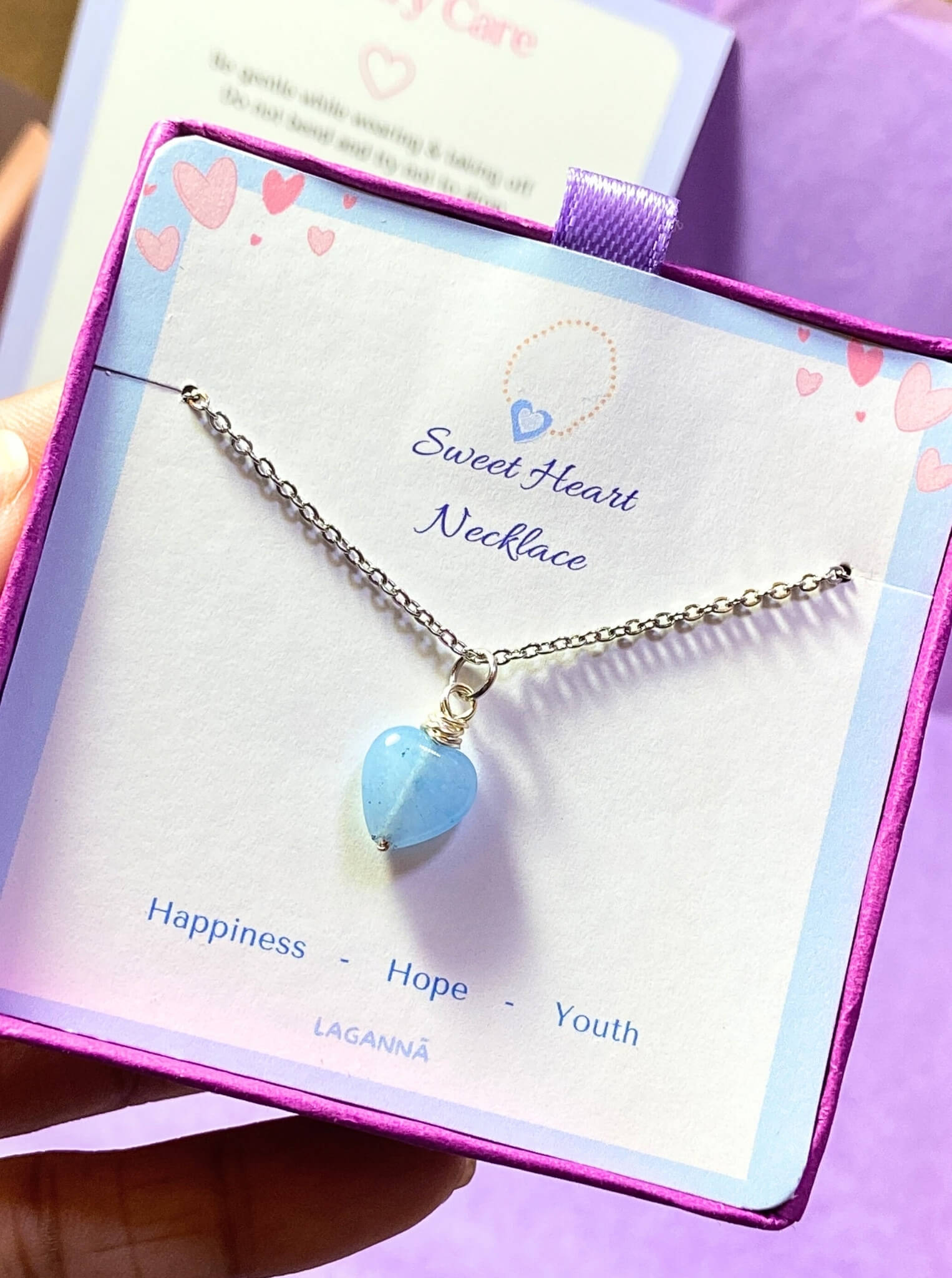 Sweet heart blue chalcedony necklace jewelry box held on hand showing silver wire wrapped design, handmade Sri Lankan heart-shaped pendant gift for calm and emotional healing