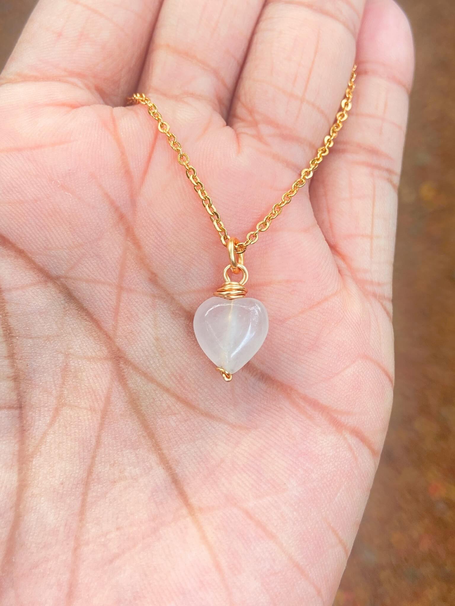 Handmade sweet heart rose quartz necklace held in hand showing gold wire wrapped healing crystal jewelry lifestyle, Sri Lankan artisan heart chakra pendant featuring natural heart-shaped pink gemstone perfect as boho love necklace and self-love amulet for emotional healing and compassion
