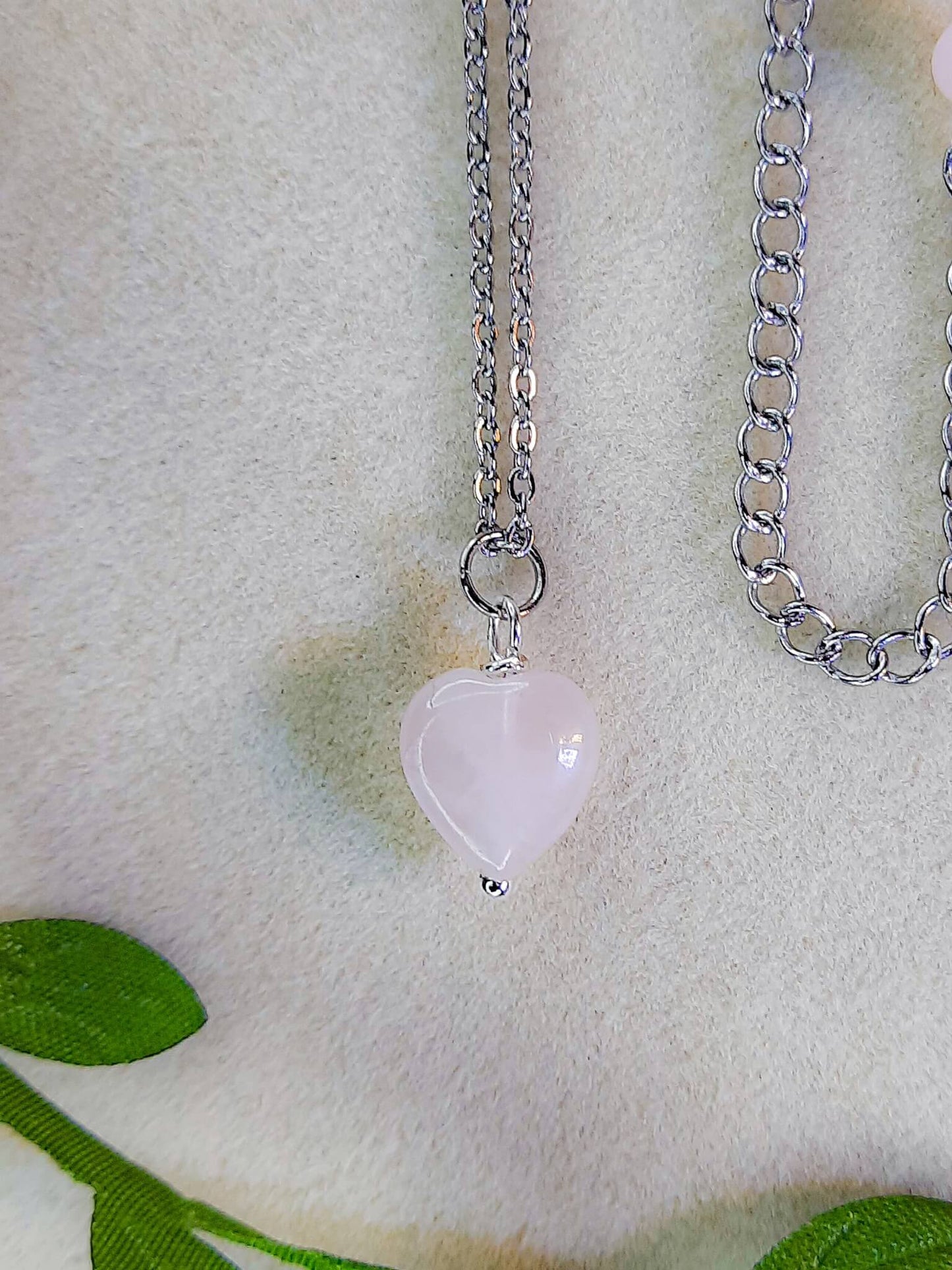 Sweet heart rose quartz necklace on soft background with leaves showing handmade silver wire wrapped healing crystal jewelry, Sri Lankan artisan heart chakra pendant featuring natural heart-shaped pink gemstone perfect as boho love necklace and self-love amulet for emotional balance and inner peace