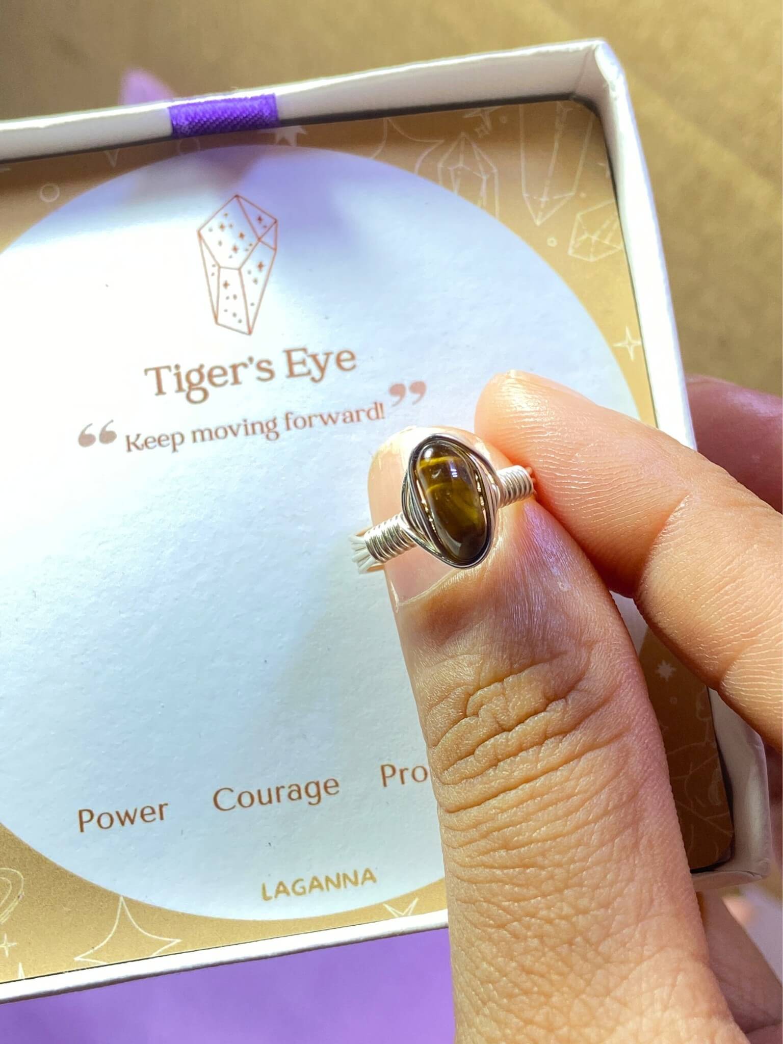 Handmade tiger's eye irregular stone ring with jewelry box packaging held in hand showing silver wire wrapped healing crystal gift set, Sri Lankan artisan courage stone ring featuring natural golden brown gemstone perfect as protection jewelry gift for confidence and grounding energy with elegant presentation