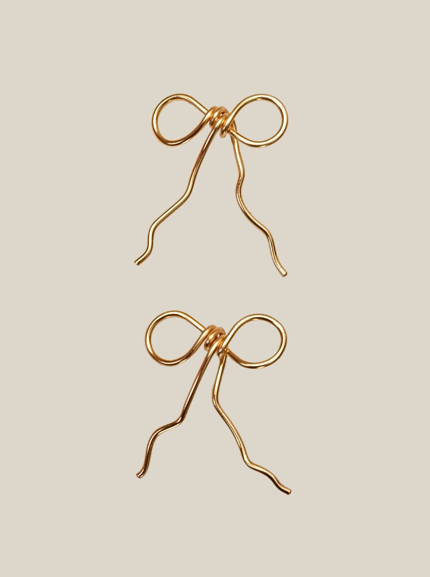 Wire-wrapped bow earrings detail shot showing delicate bow design and wire-wrapping craftsmanship, handmade artisan jewelry by Laganna Sri Lanka, available in gold plated or silver plated finish with or without Japanese Miyuki Delica glass beads, feminine lightweight earrings for women, premium handcrafted stud earrings